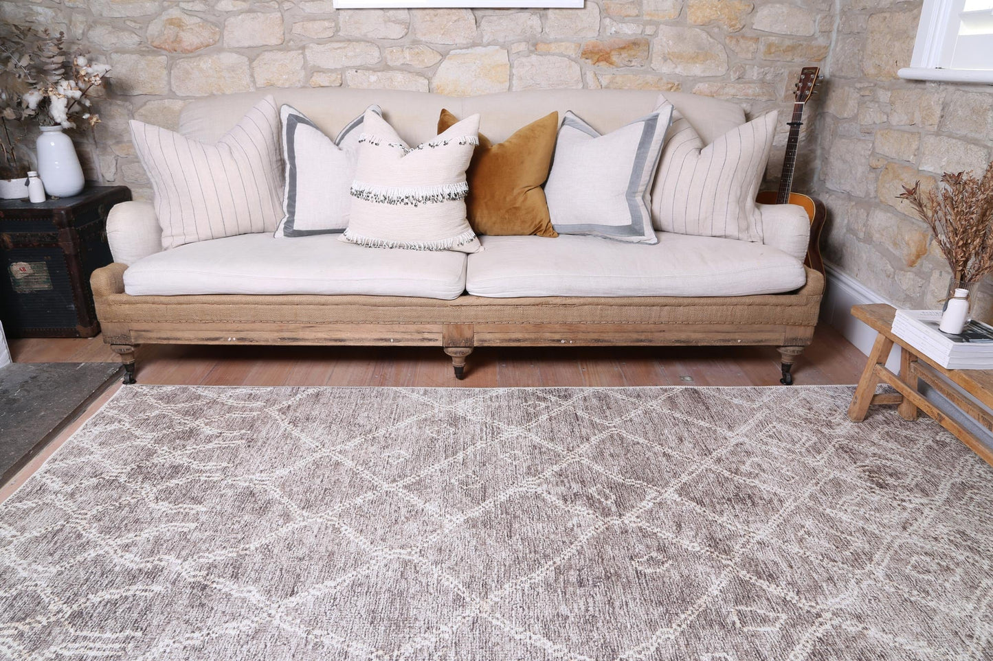 A lifestyle shot of the Nordic Nahla Beige Rug in a Scandinavian-inspired living room, featuring minimalist furniture, natural wood accents, and plenty of natural light.